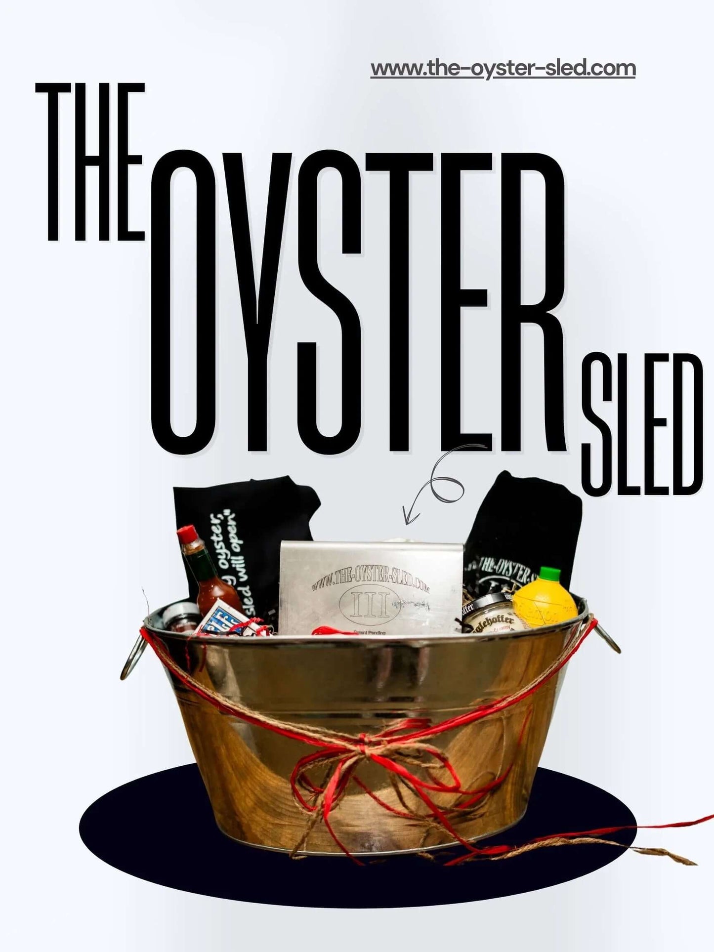 Oyster shucking kit with metal holder, gloves, hot sauce, and lemon in a tin bucket