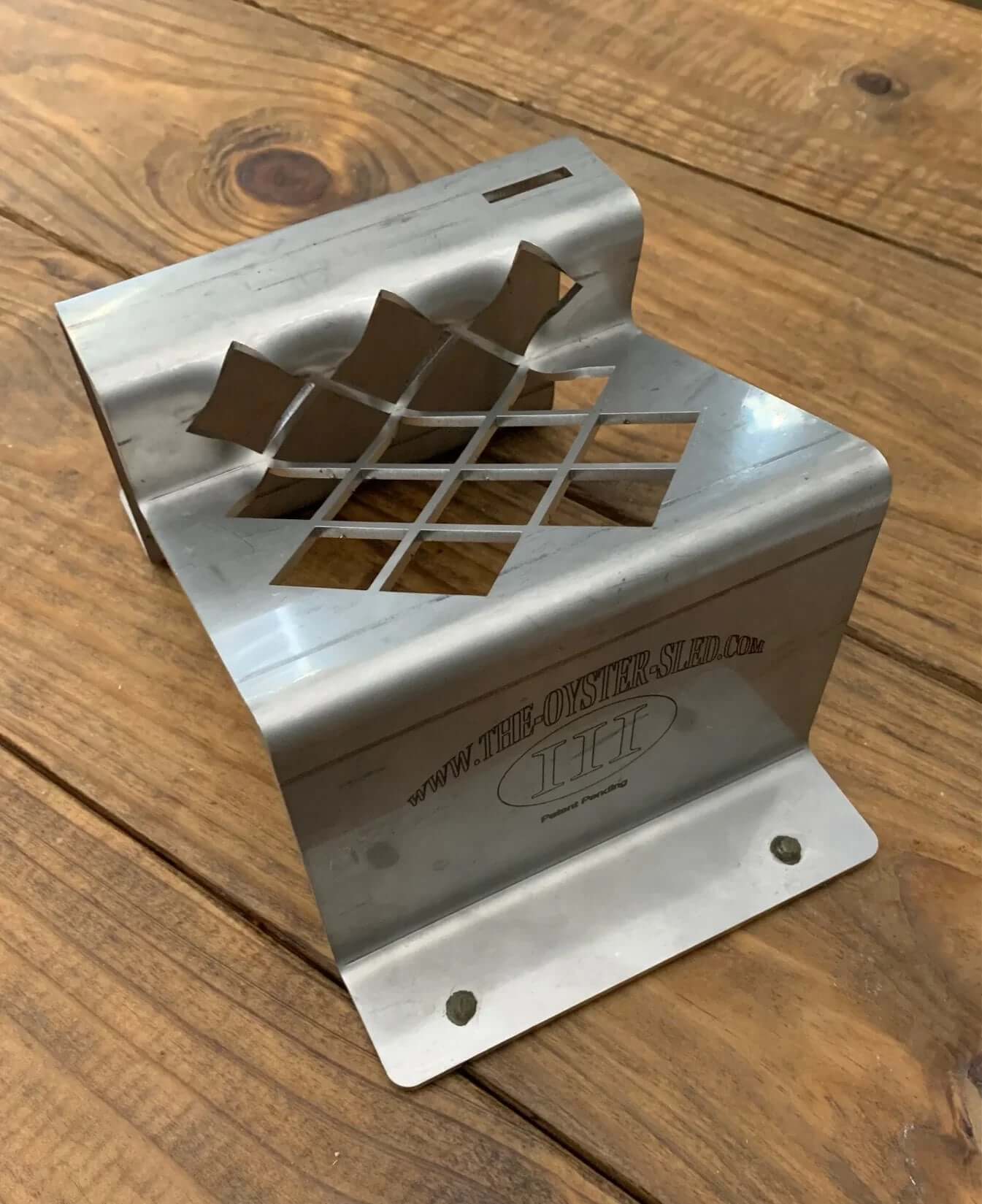 Professional oyster shucking tool holding the oyster shell safely.
Stainless steel oyster shucking holder with ergonomic design on a wooden surface